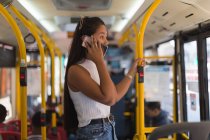 Девушка-подросток разговаривает по мобильному телефону в автобусе — стоковое фото