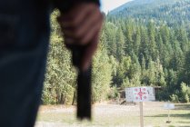 Mann an sonnigem Tag zum Schießen mit Waffe bereit — Stockfoto