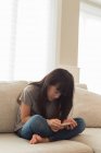 Девушка с мобильного телефона в гостиной на дому — стоковое фото