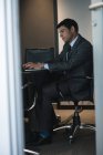 Homme d'affaires utilisant un ordinateur portable dans la chambre d'hôtel — Photo de stock