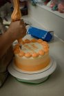 Gros plan de la femme préparant un gâteau en boulangerie — Photo de stock