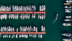 Вид сверху на лодки, пришвартованные вдоль пристани в гавани — стоковое фото