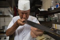 Jefe de cocina con cuchillo en la cocina del restaurante - foto de stock