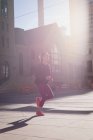 Fitte Frau wärmt sich an einem sonnigen Tag auf der Straße auf — Stockfoto