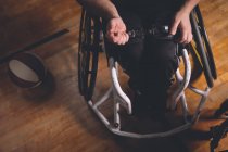 Инвалид регулирует пояс инвалидной коляски в суде — стоковое фото