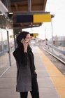 Frau im Hidschab telefoniert am Bahnhof — Stockfoto
