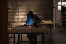 Женщина-сварщик с помощью сварочной горелки в мастерской . — стоковое фото