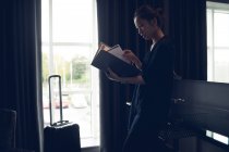 Жінка читає документи в готельному номері — стокове фото