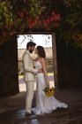 Романтична наречена і наречена стоять обличчям до обличчя в саду — стокове фото