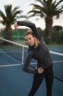 Giovane donna che esercita nel campo da tennis — Foto stock