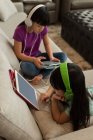 Geschwister mit Kopfhörern nutzen digitales Tablet zu Hause — Stockfoto