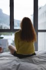 Visão traseira da mulher relaxando no quarto em casa — Fotografia de Stock