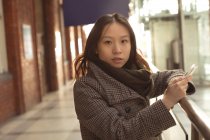 Портрет женщины, использующей мобильный телефон в железнодорожной форме — стоковое фото