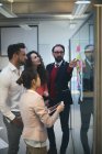 Керівники бізнесу обговорюють над липкими нотатками в офісі — стокове фото