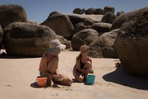 Мать и дочь играют на песке на пляже — стоковое фото