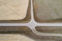 Воздух пустой дороги, проходящей через пшеничное поле — стоковое фото