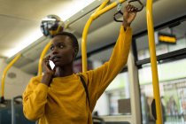 Jovem mulher falando no celular enquanto viaja no ônibus — Fotografia de Stock