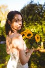 Portrait of beautiful bride holding a sunflower bouquet in the garden — Stock Photo