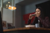 Жінка фотографує їжу з мобільним телефоном в ресторані — стокове фото
