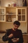 Homem tomando café da manhã na cozinha em casa — Fotografia de Stock