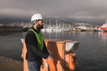 Trabajador portuario con guantes en el astillero en un día soleado - foto de stock