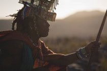 Масаї людина в традиційному одязі, сидячи в сільській місцевості — стокове фото