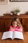 Fleißiges Mädchen liest zu Hause ein Buch — Stockfoto