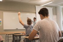 University student raising hand in classroom at university — Stock Photo