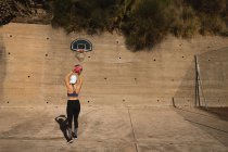 Visão traseira da mulher jogando basquete na quadra de basquete — Fotografia de Stock