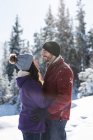 Casal abraçando e olhando uns para os outros em bosques invernais . — Fotografia de Stock