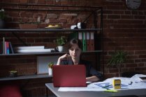 Молодая женщина-руководитель с ноутбуком в офисе — стоковое фото
