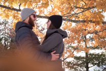 Casal romântico abraçando uns aos outros durante o outono — Fotografia de Stock