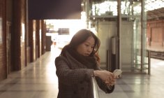 Красива жінка використовує мобільний телефон у залізничній формі — стокове фото