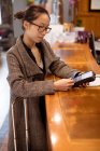 Mulher executiva deslizando seu cartão na máquina terminal de pagamento na área de recepção — Fotografia de Stock