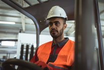 Male worker driving forklift in the warehouse — Stock Photo