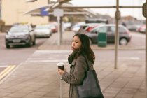 Mulher com bagagem em pé no stand de táxi — Fotografia de Stock