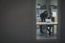 Führungskräfte diskutieren über Laptop im modernen Büro — Stockfoto