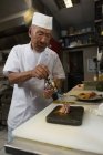 Chef riscaldamento frutti di mare con bruciatore in cucina al ristorante — Foto stock