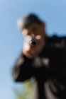 Homem desfocado apontando rifle sniper no alvo no alcance de tiro — Fotografia de Stock
