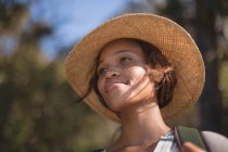 Young female hiker in straw hat standing at countryside — Stock Photo