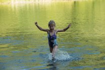 Mädchen spielt an einem sonnigen Tag im Fluss — Stockfoto