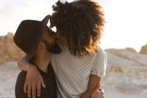 Романтична пара цілується один з одним на пляжі під час заходу сонця — стокове фото