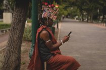 Maasai мужчина в традиционной одежде с помощью мобильного телефона на дороге — стоковое фото