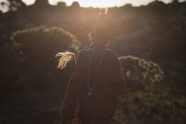 Масаї людина в традиційному одязі стоячи з палицею в сільській місцевості — стокове фото