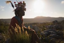 Massai-Mann in traditioneller Kleidung sitzt an einem sonnigen Tag auf dem Land — Stockfoto