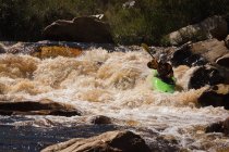 Mujer kayak en agua de río de montaña a la luz del sol . - foto de stock