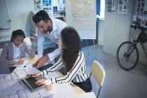 I dirigenti discutono sopra computer portatile in ufficio moderno — Foto stock