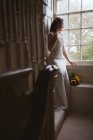 Bride looking out of the window at home — Stock Photo