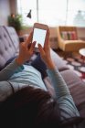 Frau benutzt Handy im heimischen Wohnzimmer — Stockfoto