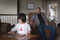 Girl standing near the table while father looking her at home — Stock Photo